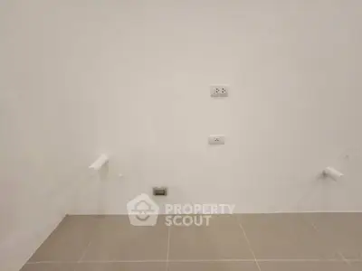 Minimalist interior wall with electrical outlets and tiled floor