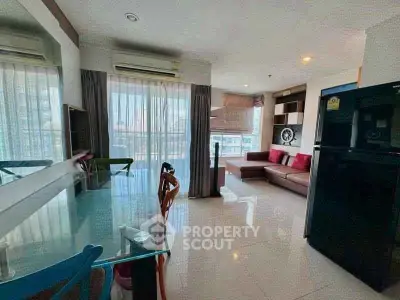 Modern living room with dining area and large windows in a bright apartment.