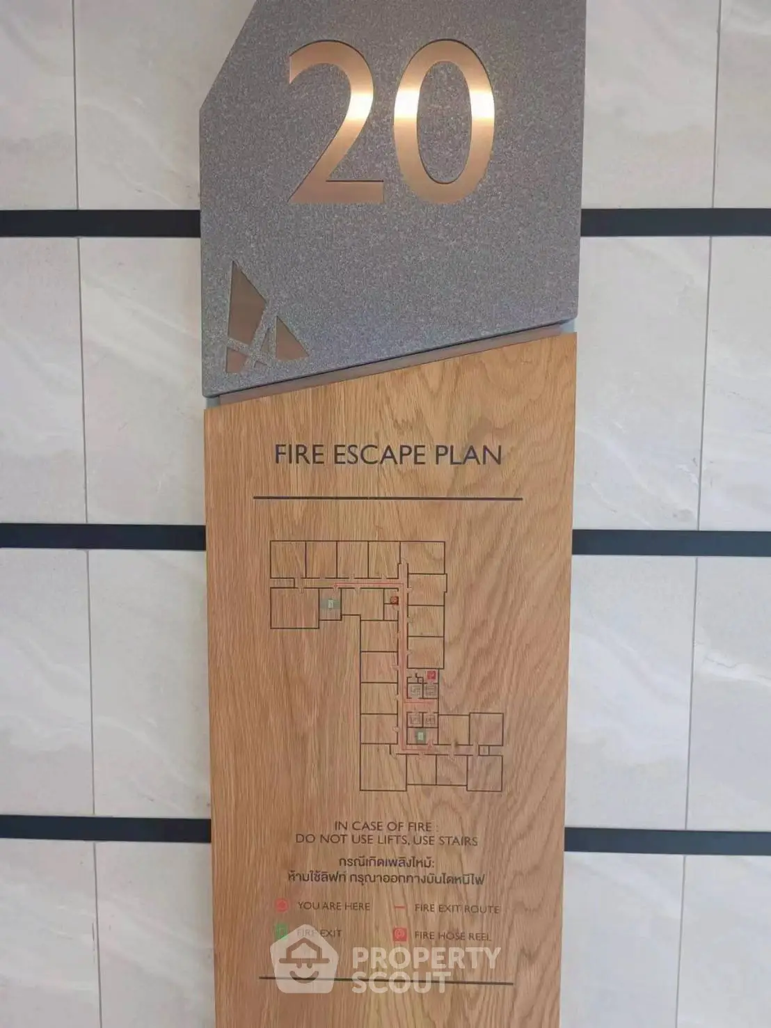 Modern fire escape plan on wooden panel for high-rise building safety.