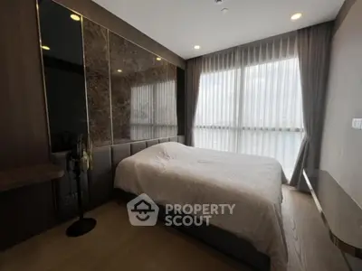 Luxurious bedroom with large windows and elegant decor in modern apartment.
