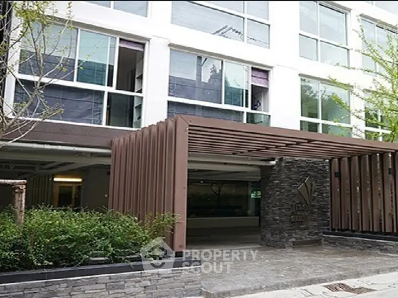 Modern building entrance with stylish pergola and stone accents