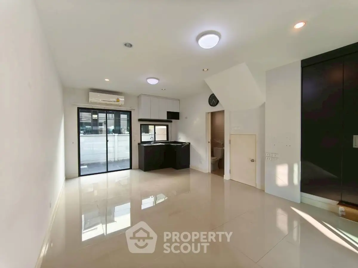 Modern open-plan living room with sleek kitchen and ample natural light