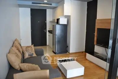 Modern compact living room with sleek furniture and integrated kitchen area.