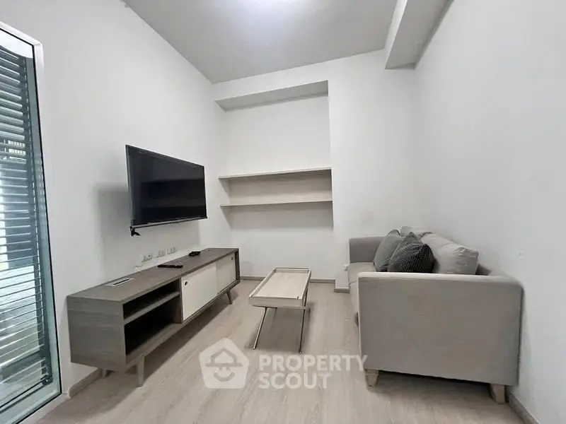 Modern living room with sleek furniture and wall-mounted TV, ideal for cozy gatherings.