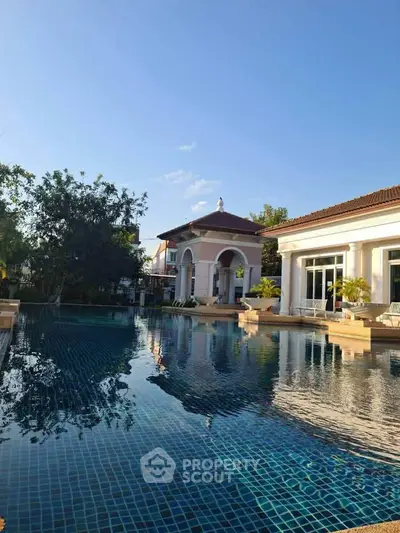 Luxurious villa with stunning pool and elegant architecture under clear blue sky.