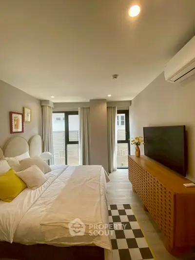 Modern bedroom with stylish decor, large windows, and air conditioning unit.