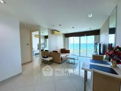 Spacious living room with ocean view, modern furniture, and elegant decor in a high-rise apartment.