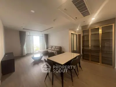 Spacious modern living room with elegant dining area and large windows for natural light.