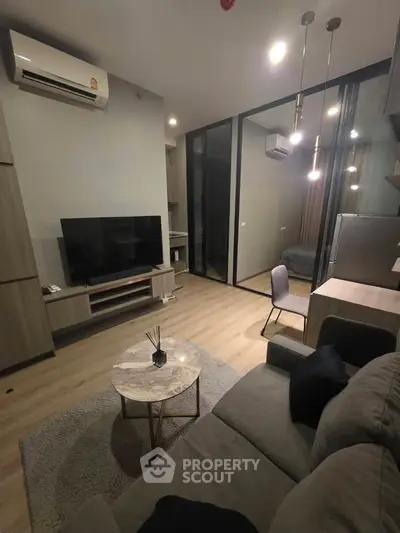 Modern living room with sleek furniture and open layout, featuring a cozy sofa and stylish decor.
