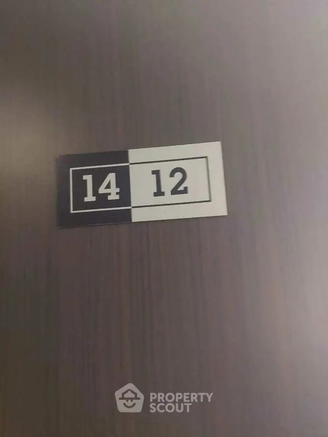 Stylish apartment door with modern number plaque in sleek hallway.