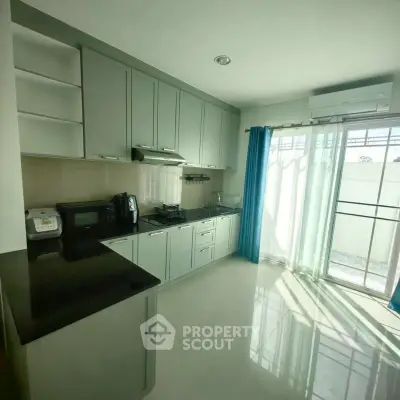 Modern kitchen with sleek cabinetry and natural light in a stylish apartment.