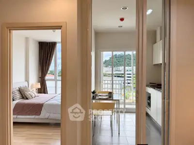 Modern apartment interior with bedroom and kitchen, featuring a scenic balcony view.
