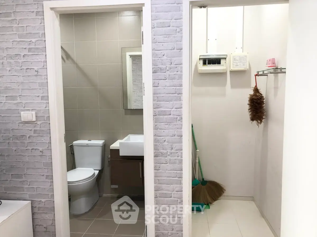 Compact bathroom and utility area with modern fixtures and cleaning tools.