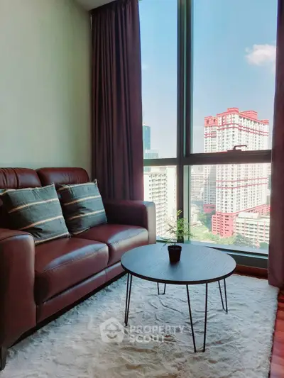 Stylish living room with city view, featuring leather sofa and modern coffee table.