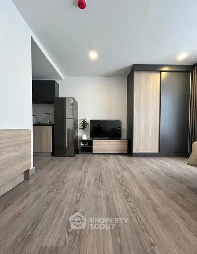 Modern living room with sleek kitchen and stylish wood flooring