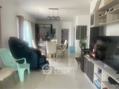 Spacious living room with modern furniture and massage chair, perfect for relaxation and entertainment.