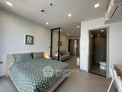 Modern bedroom with stylish decor and ensuite bathroom in a contemporary apartment.