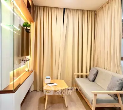 Cozy living room with modern decor and natural light, featuring a comfortable sofa and stylish wooden table.