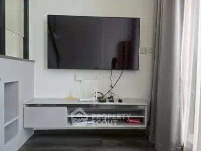 Modern living room with wall-mounted TV and sleek white entertainment unit.