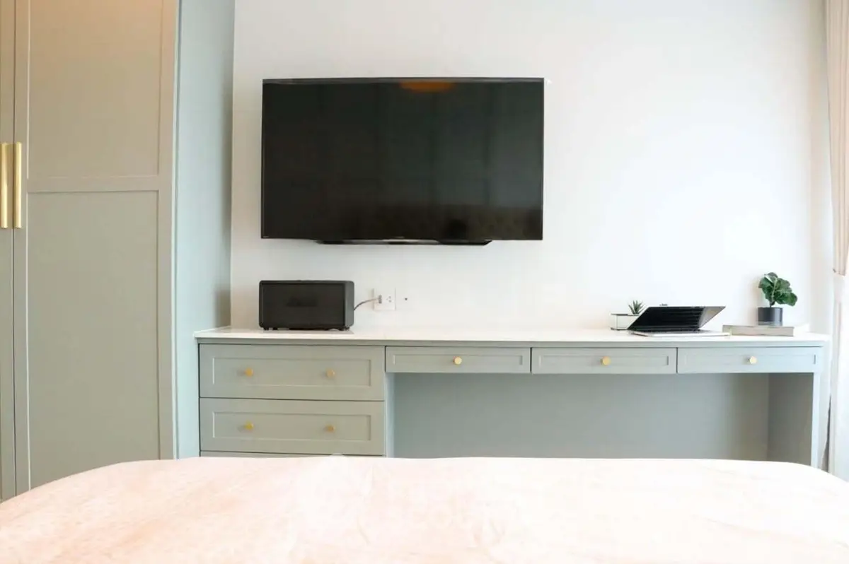 Modern bedroom with wall-mounted TV and stylish cabinetry
