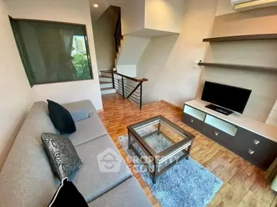 Modern living room with sleek furniture and stylish decor, featuring a cozy sofa and elegant TV setup.