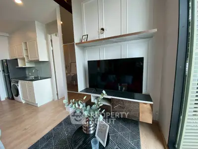 Modern living room with sleek TV setup and compact kitchen area
