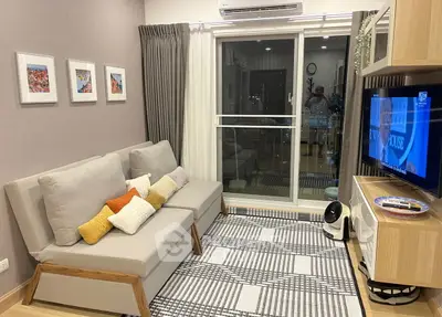 Cozy living room with modern decor and balcony view, perfect for relaxation.