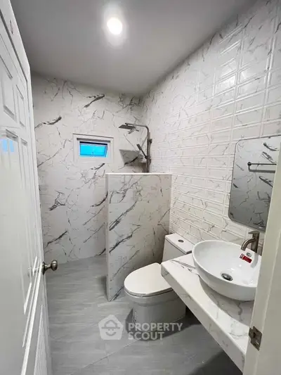 Modern bathroom with marble tiles and sleek fixtures