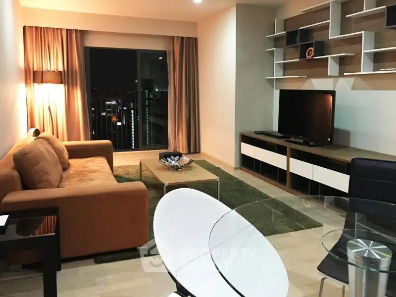 Modern living room with city view, stylish furniture, and open layout in a high-rise apartment.