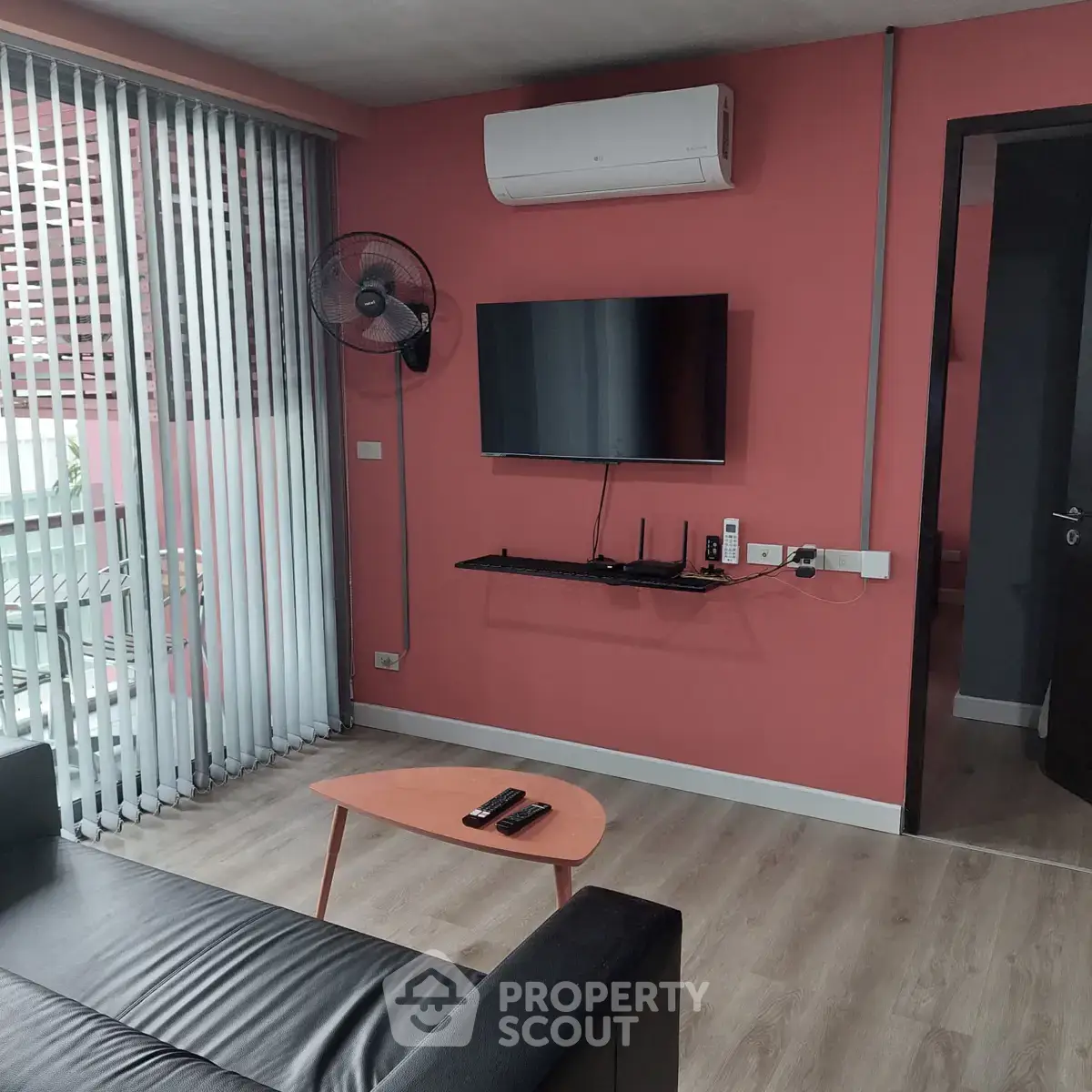 Modern living room with air conditioning and wall-mounted TV, featuring sleek design and natural light.