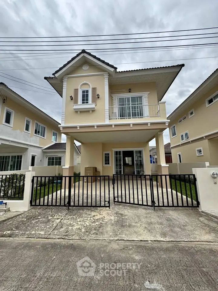 Charming two-story house with gated driveway and modern facade in a suburban neighborhood.