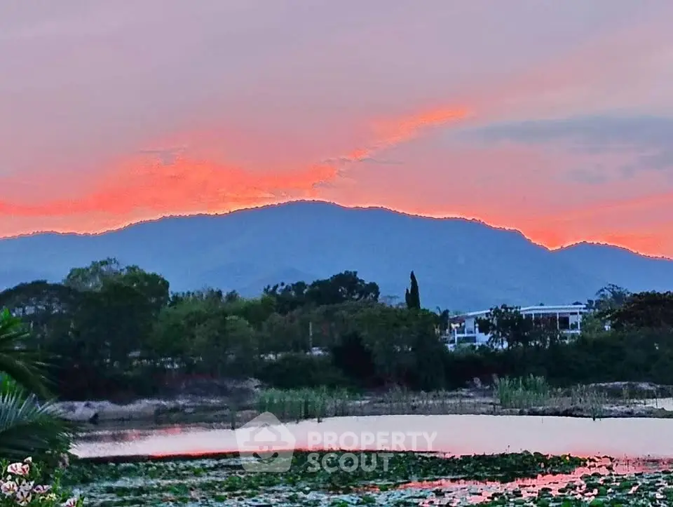 Stunning sunset view over serene lake with mountain backdrop, perfect for tranquil living.
