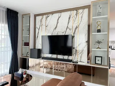 Luxurious living room with modern TV setup and elegant marble accents