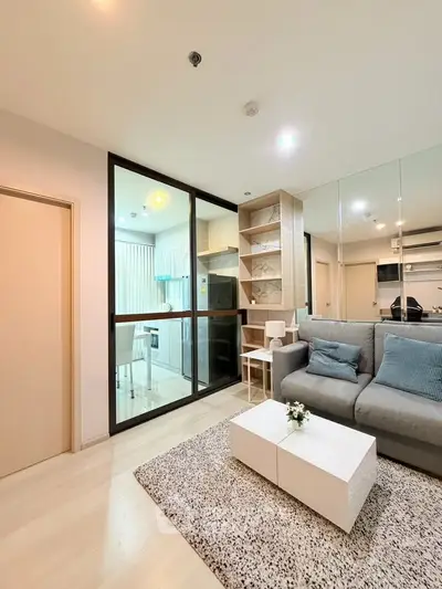 Modern living room with glass partition, cozy sofa, and stylish decor in a contemporary apartment.