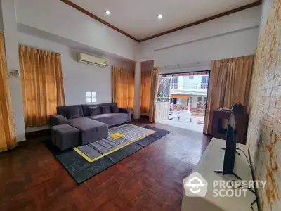 Spacious living room with modern sofa and large window offering natural light