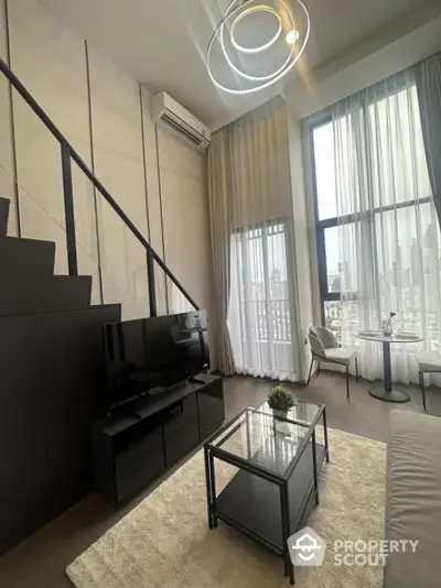 Modern loft apartment with high ceilings and city view, featuring stylish living area and large windows.