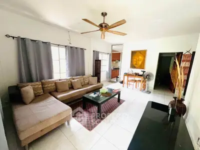 Spacious living room with modern decor and ceiling fan, perfect for relaxation.