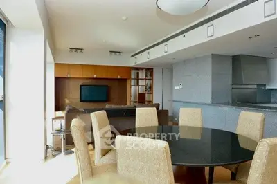Spacious modern living room with dining area and open kitchen in luxury apartment.