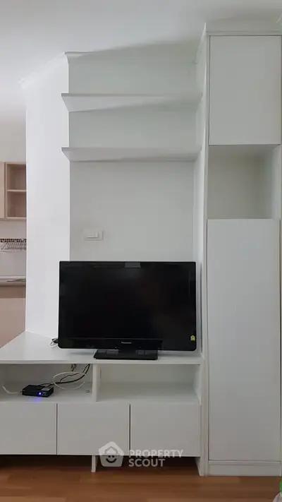 Modern living room with sleek white entertainment unit and flat-screen TV