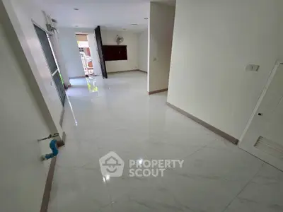 Spacious unfurnished interior with glossy tiled floors and open layout, ideal for customization.