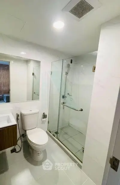 Modern bathroom with glass shower enclosure and sleek fixtures
