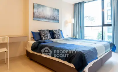 Modern bedroom with large window and stylish decor in a contemporary apartment.