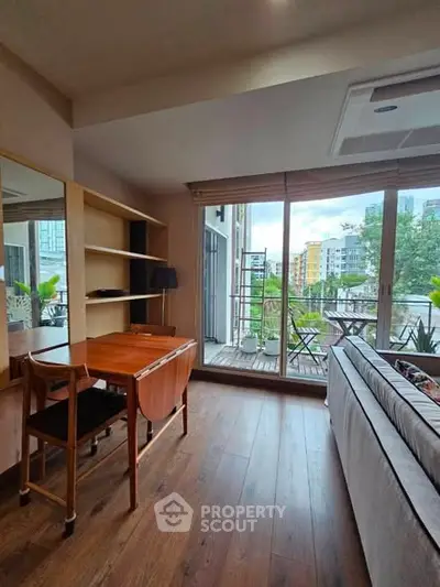 Chic living room with wooden flooring and balcony view in modern apartment