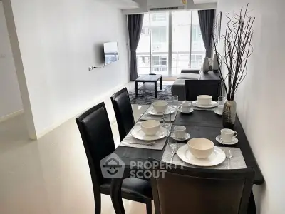 Modern dining area with elegant table setting and cozy living room view.
