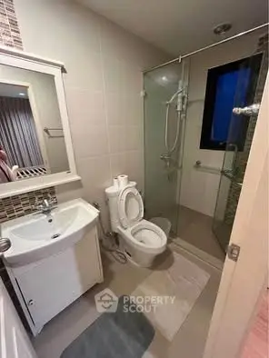 Modern bathroom with glass shower and sleek white fixtures