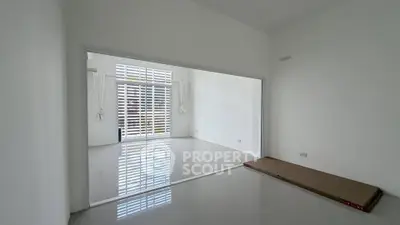 Spacious modern living room with large windows and sleek white tiles
