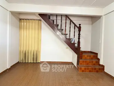 Spacious interior with wooden staircase and tiled flooring, ideal for creative home design.