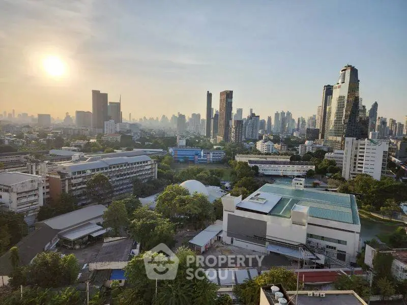 Stunning city skyline view with modern skyscrapers and lush greenery at sunset.