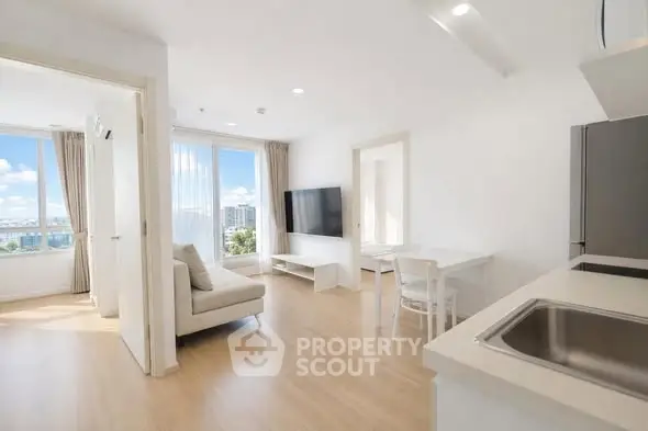 Bright modern living room with open kitchen and city view