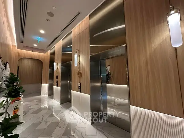 Luxurious modern elevator lobby with elegant wood paneling and marble flooring.